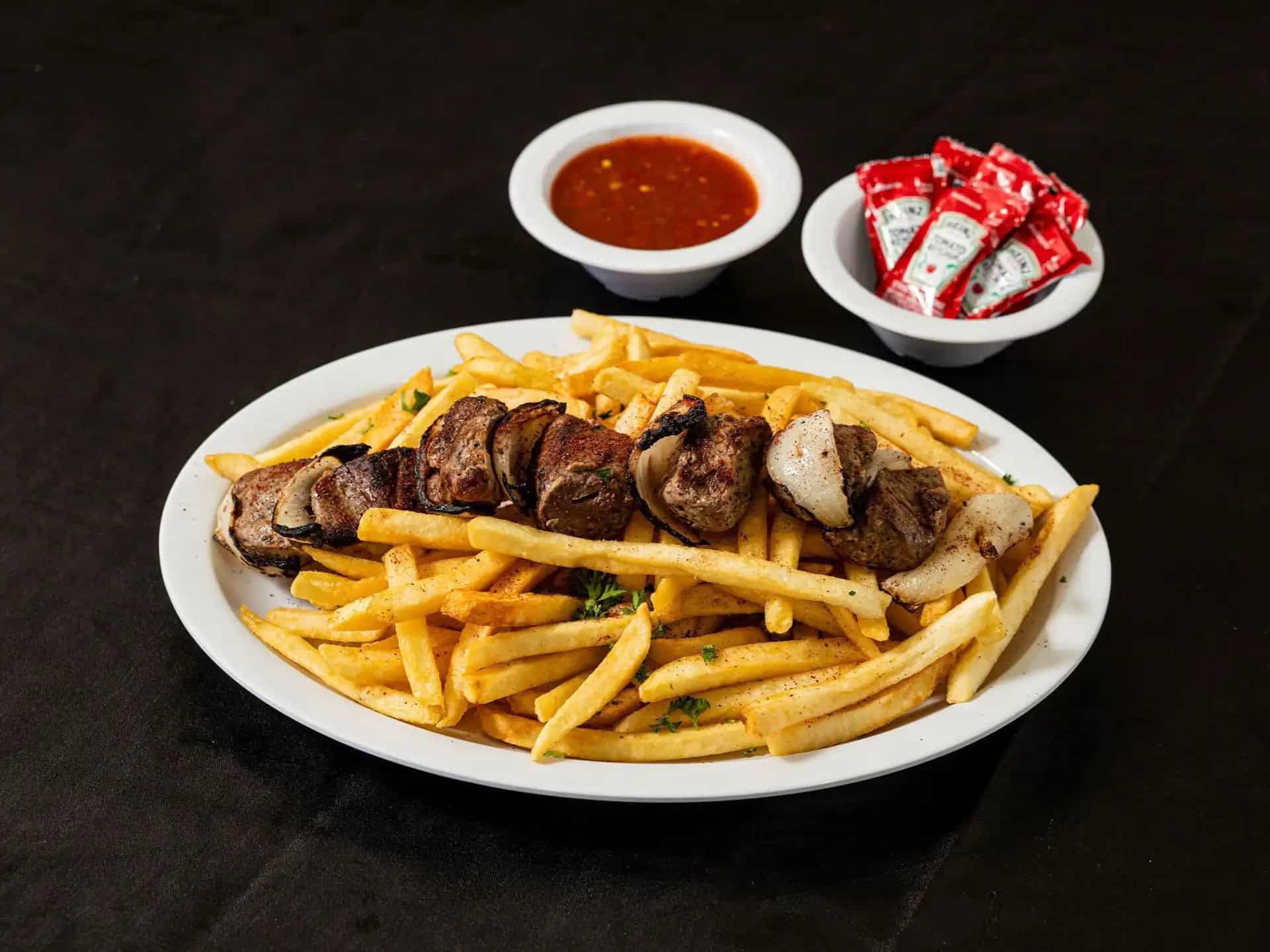 Beef Kebab Fries at Shawarma House SD — crispy seasoned fries loaded with halal beef kebab, garden salad, and sauces — Iraqi-Mediterranean restaurant in Ocean Beach