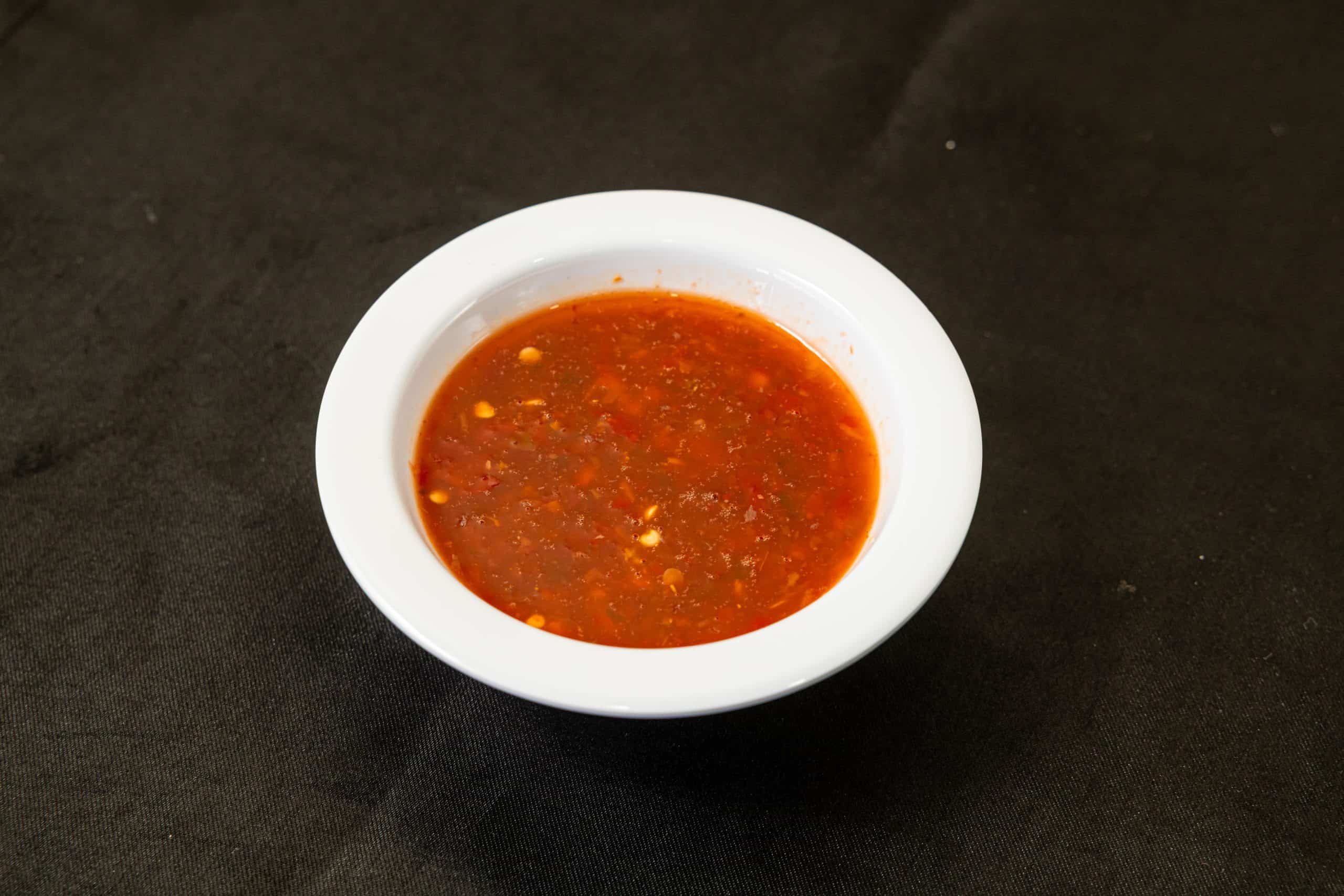 Chili Sauce at Shawarma House SD — house Iraqi-style hot sauce, vinegar-forward and garlic-bright with slow-build heat, made fresh in-house — vegan Mediterranean in Ocean Beach