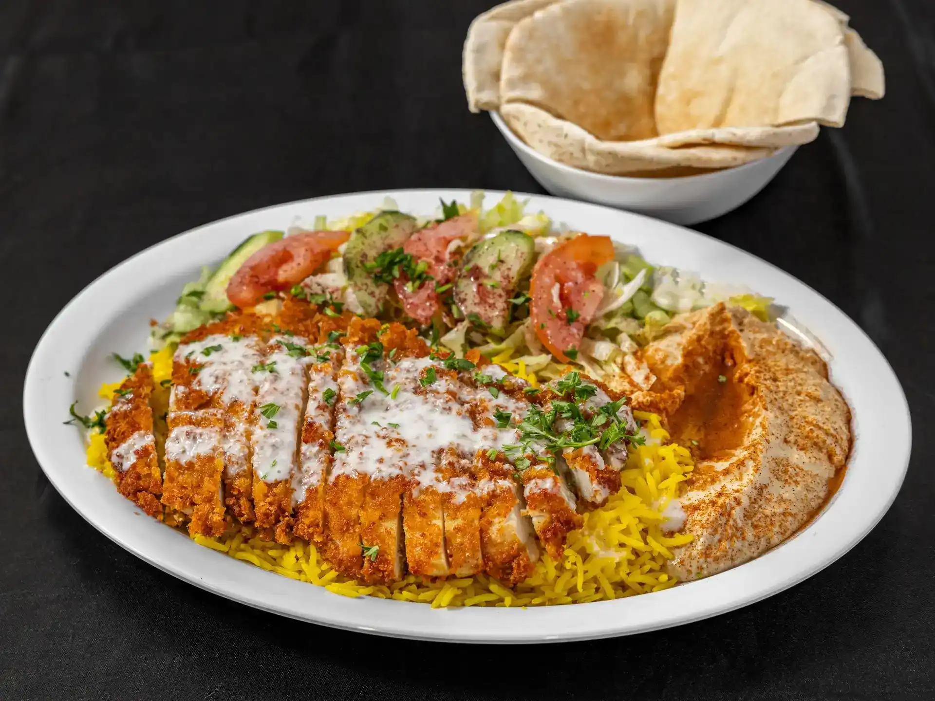 Cream Chop Plate at Shawarma House SD — chopped chicken cream chop with creamy garlic finish over saffron basmati with crisp salad, fresh hummus, and pita — Iraqi-Mediterranean restaurant in Ocean Beach