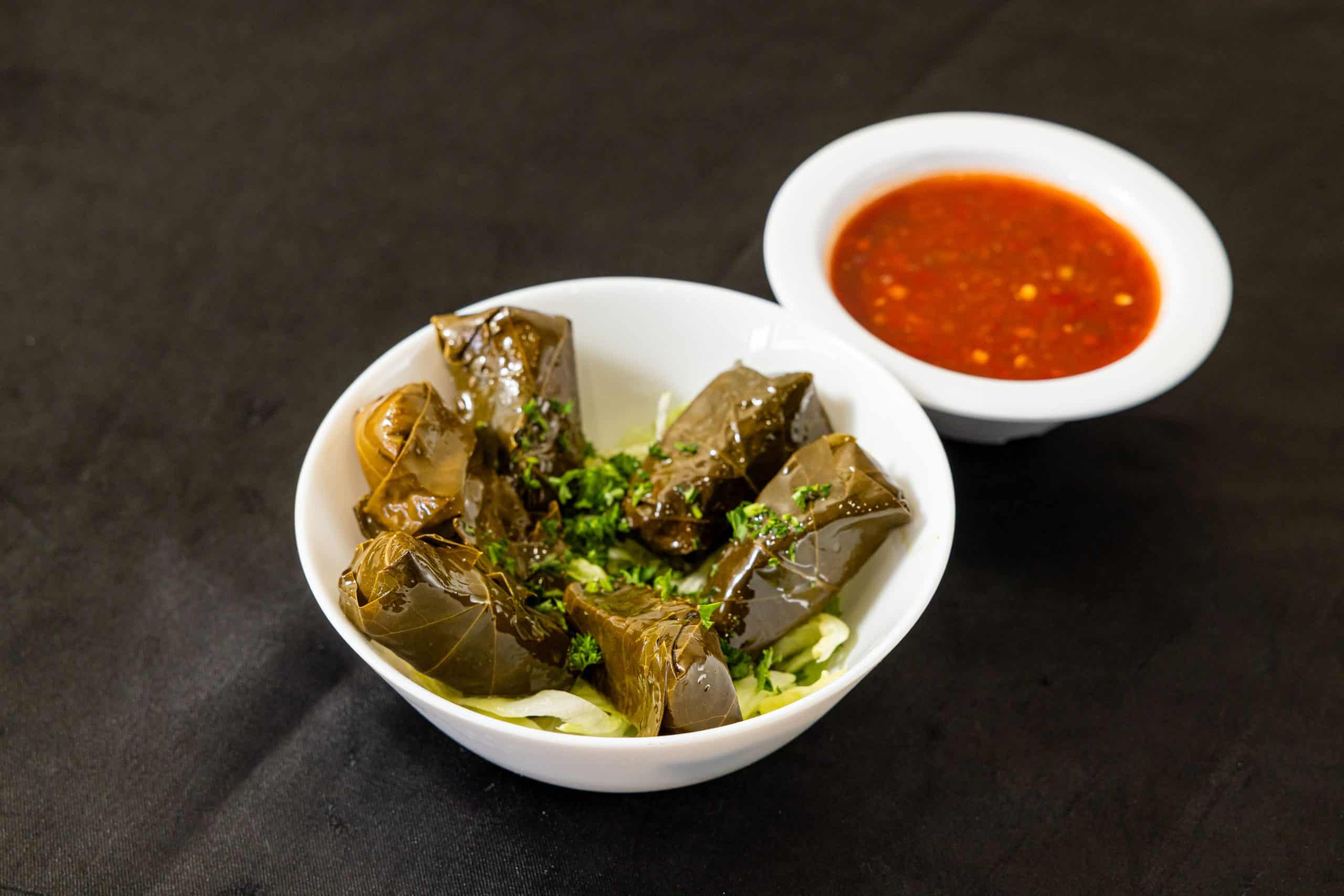 Dolmas at Shawarma House SD — five hand-rolled grape leaves stuffed with seasoned rice, fresh herbs, and lemon — vegan Levantine starter in Ocean Beach, San Diego