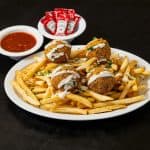 Falafel Fries at Shawarma House SD — crispy seasoned fries loaded with hand-formed chickpea falafel and tahini drizzle —