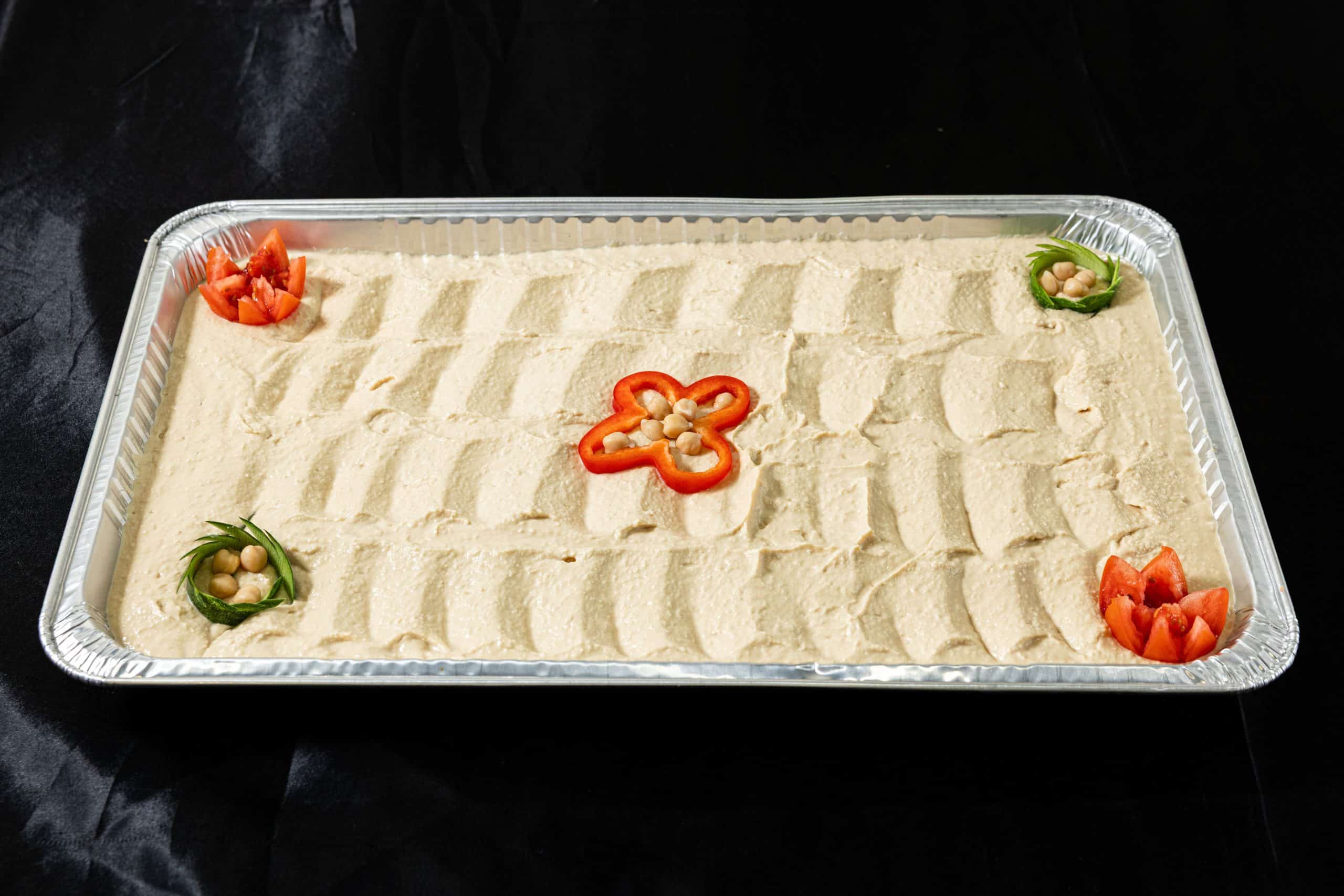 Hummus Tray at Shawarma House SD — catering tray of garlicky chickpea-tahini hummus with olive oil and paprika — vegan and gluten-free — Iraqi-Mediterranean restaurant in San Diego