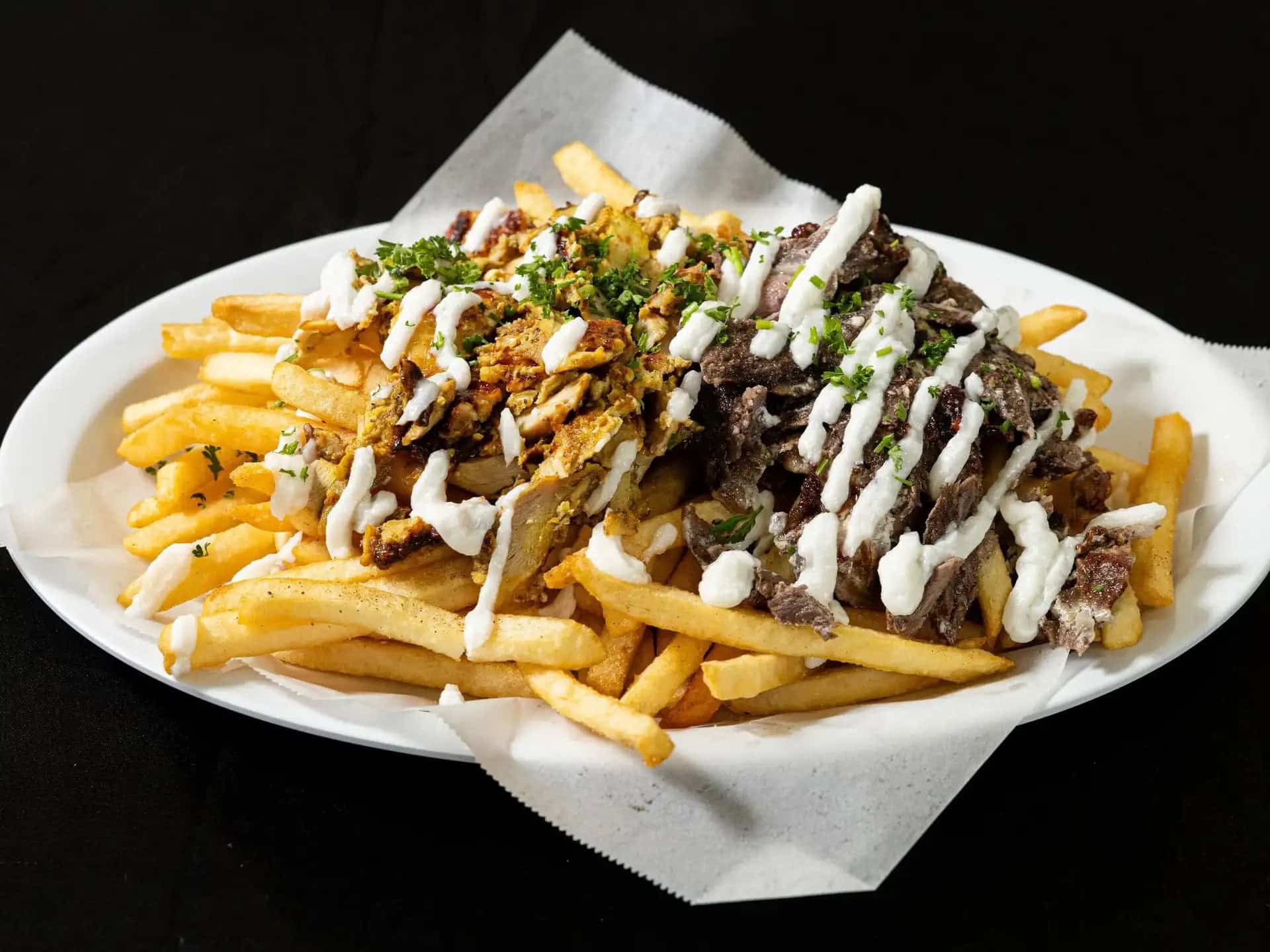 Shawarma Portion Fries at Shawarma House SD — crispy seasoned fries loaded with extra-heaping shawarma portion, salad, and sauces — Mediterranean in Ocean Beach, San Diego