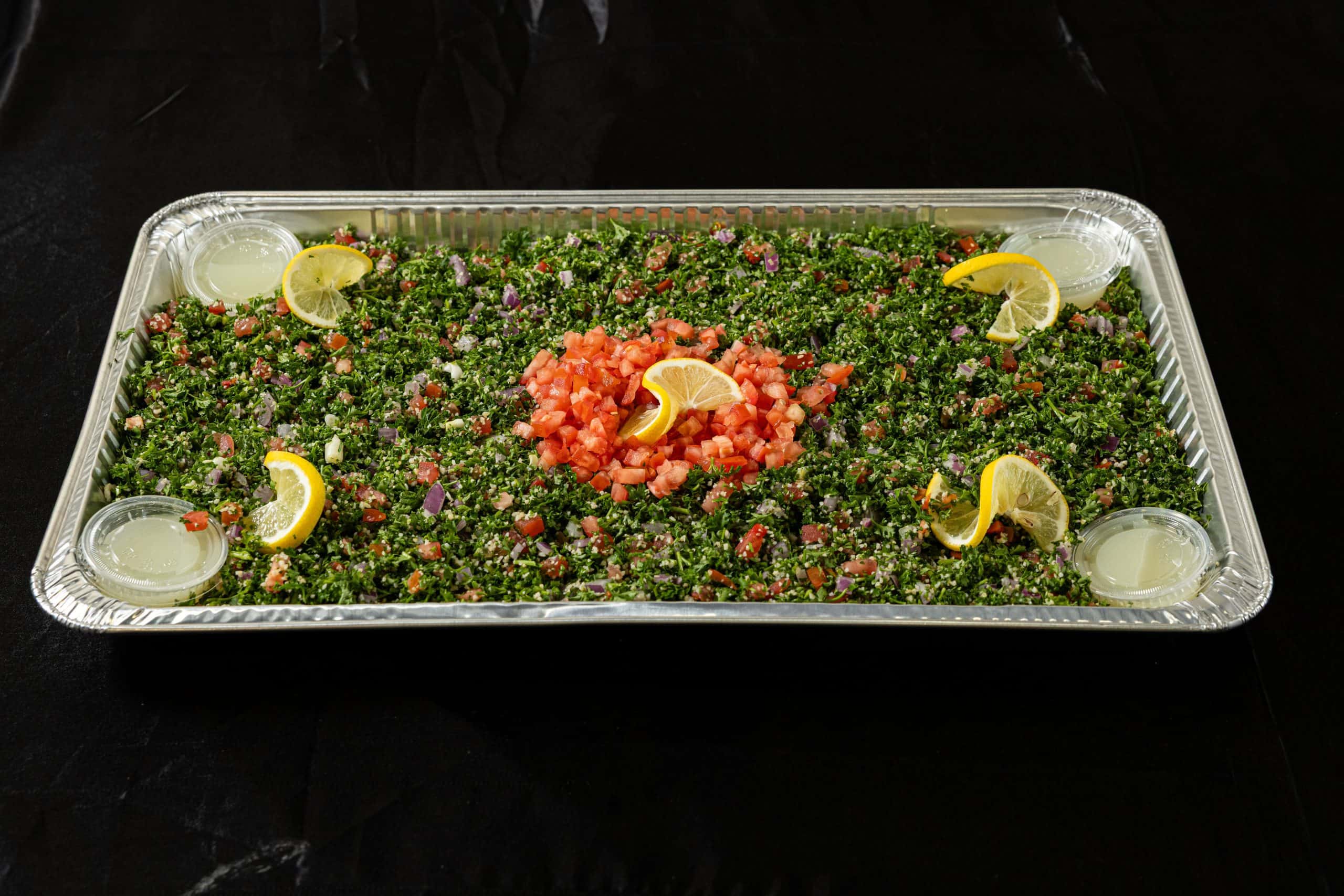 Tabouli Tray at Shawarma House SD — catering tray of parsley-bulgur salad with tomato, mint, lemon, and olive oil — vegan Levantine starter — Iraqi-Mediterranean restaurant in Ocean Beach